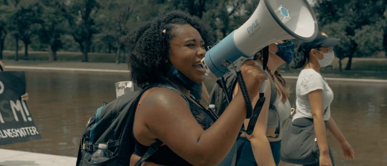 Black woman talking into a megaphone