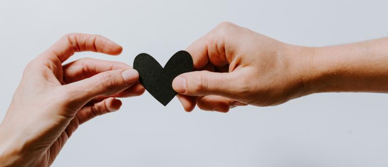 two hands holding paper heart