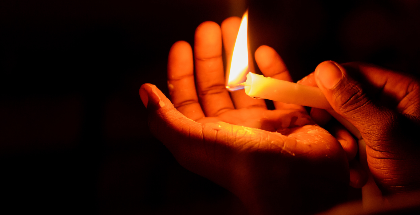 Hands around a burning candle