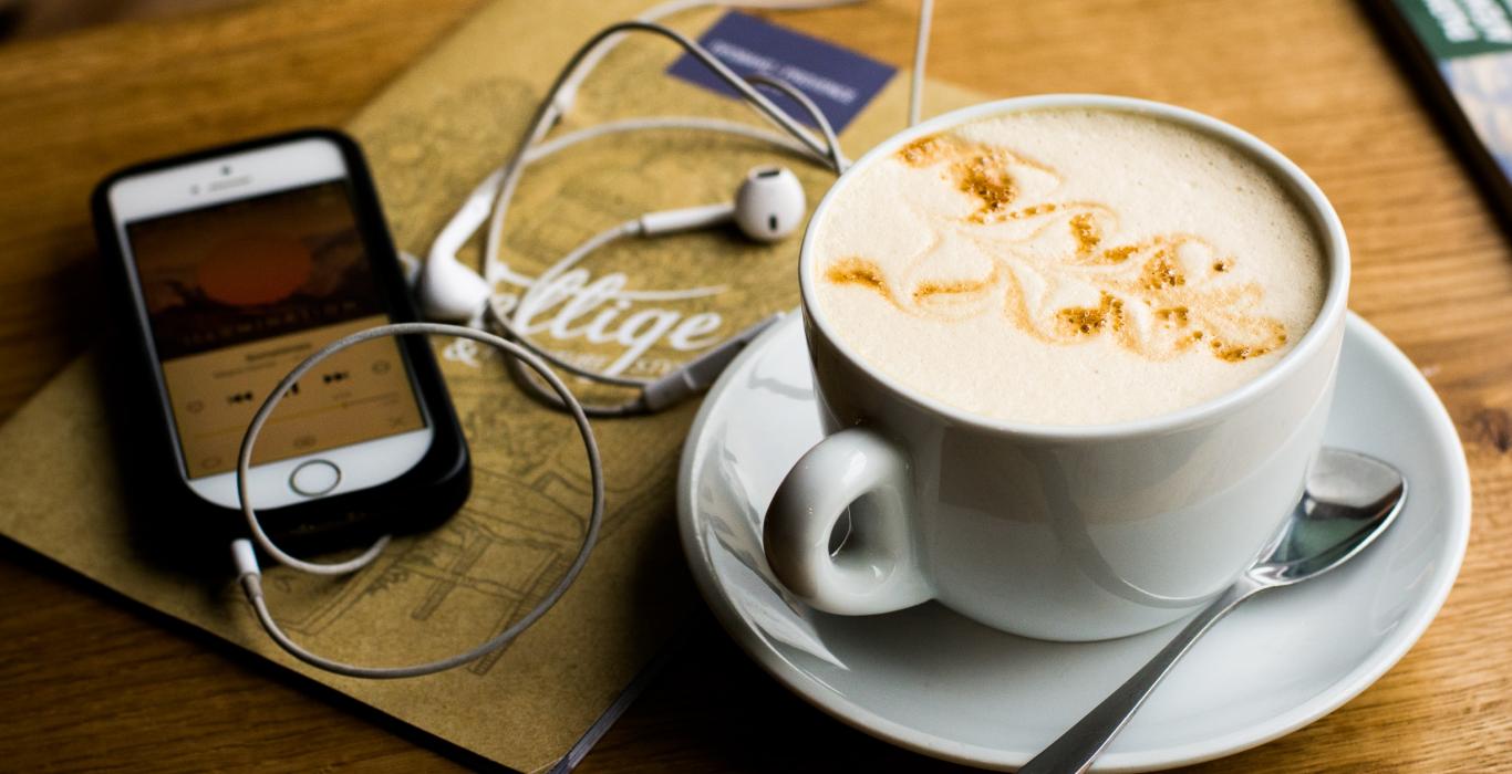 Photo of coffee, phone and earbuds
